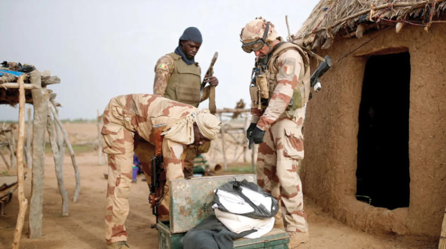 جنديان من القوات المسلحة المالية مع جندي فرنسي خلال مشاركتهم بدورية مشتركة في نداكي بمالي مع تصاعد أعمال العنف (رويترز)