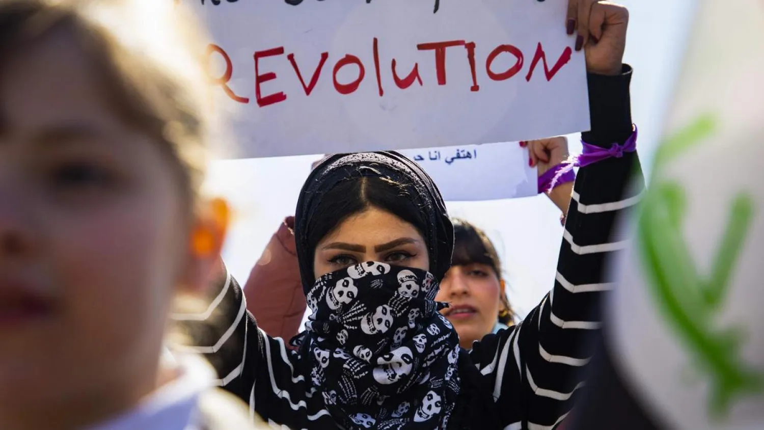 An Iraqi woman raises a placard as she takes part in an anti-government demonstration in the southern city of Basra on February 13, 2020. (AFP)