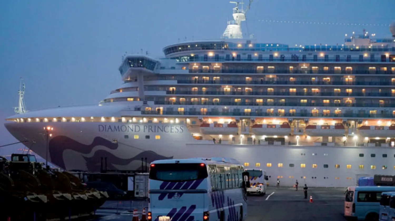 وصول حافلات إلى ميناء دايكوكو الياباني استعداداً لإجلاء أميركيين على متن {السفينة الموبوءة} أمس (إ.ب.أ)