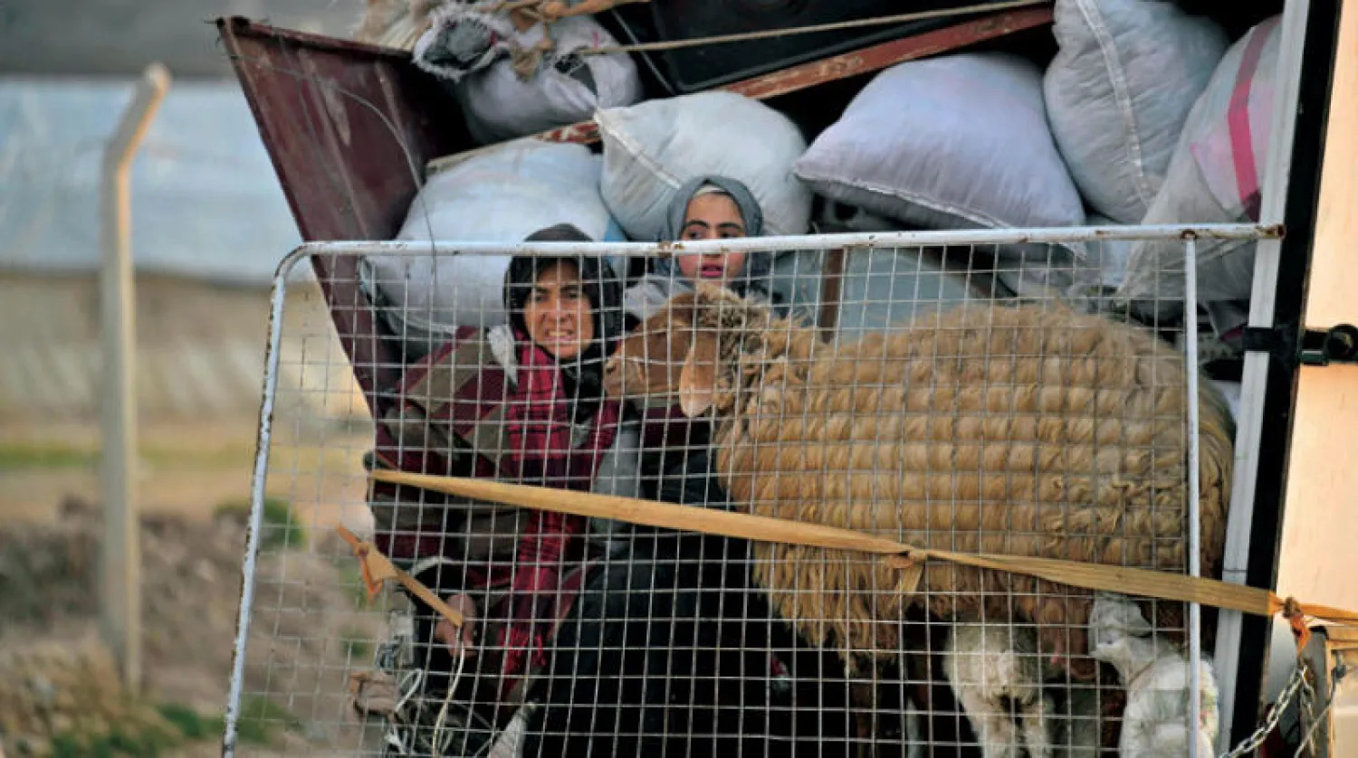 عربة محمّلة بالنازحين تصل إلى مخيم قرب عفرين شمال غرب سوريا أمس (أ.ف.ب)