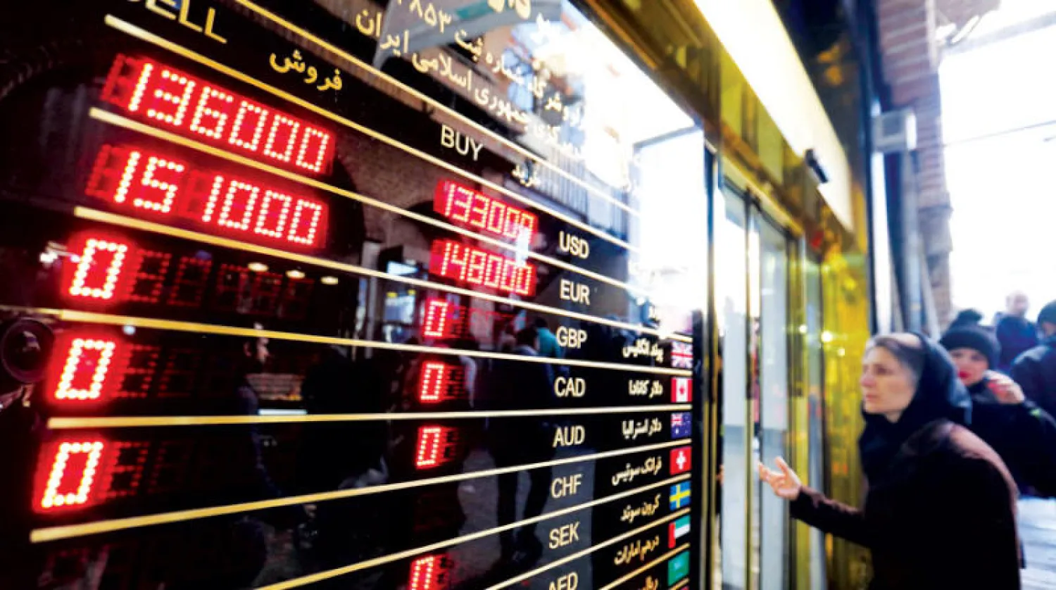 قبل قرار {فاتف} ساد ترقب كبير حيث تقف امرأة خارج دار صرافة في طهران لمراقبة الأسعار (أ.ف.ب)