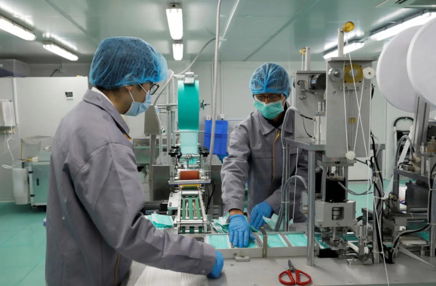 عمال يصنعون القناعات الواقية للحماية من تفشي فيروس كورونا في هونغ كونغ (رويترز)