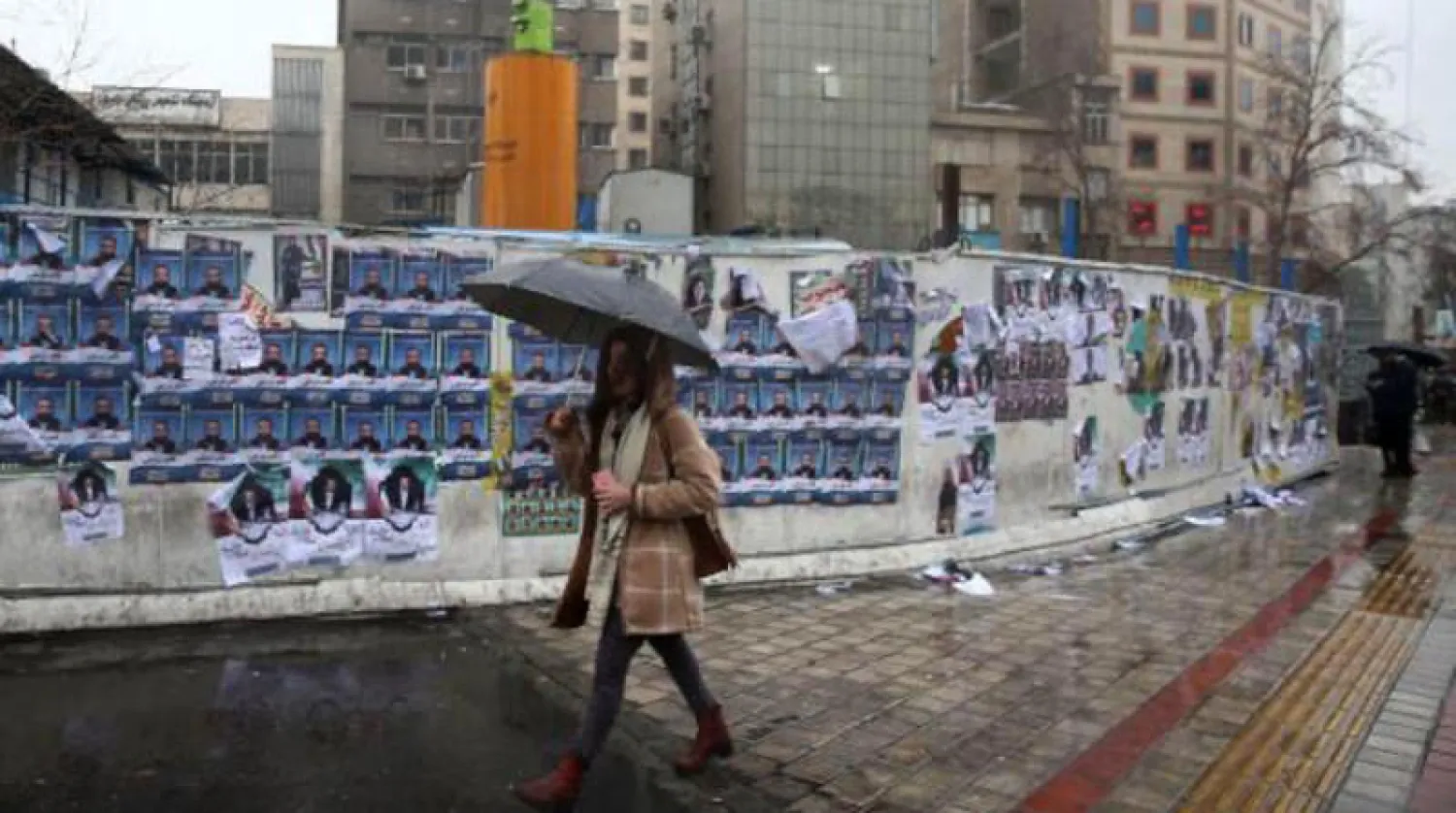 إرانية تمر من أمام جدار مخصص للحملة الانتخابية في شارع وسط طهران أمس (رويترز)