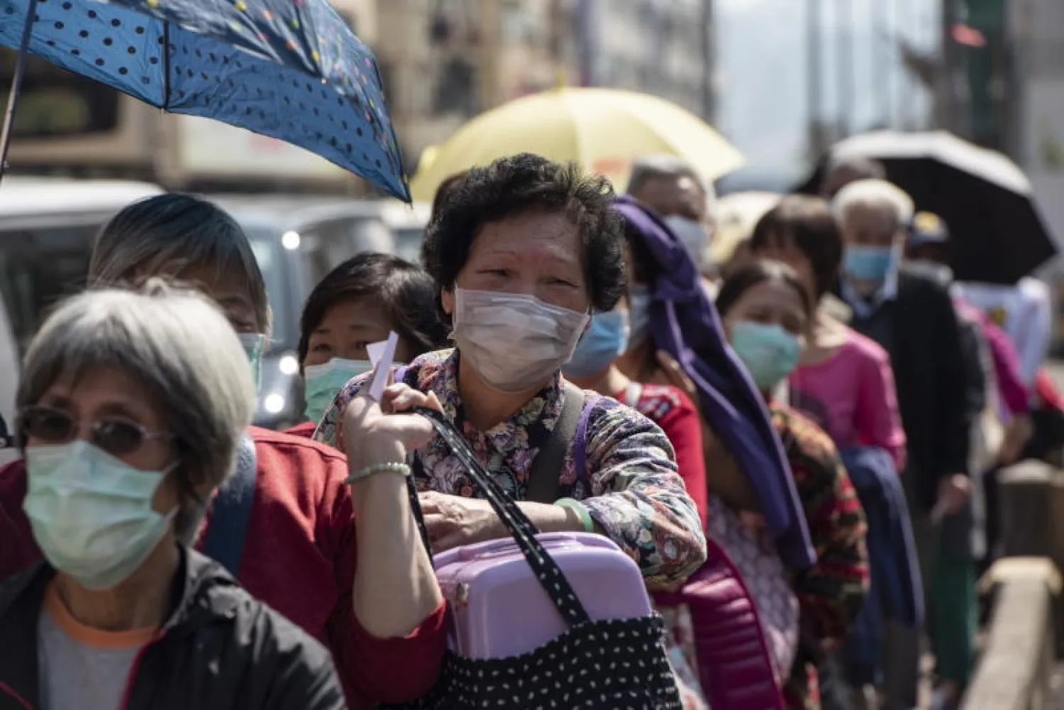 سكان في هونغ كونغ يقفون في طابور للحصول على أقنعة واقية مجانية (إ.ب.أ)