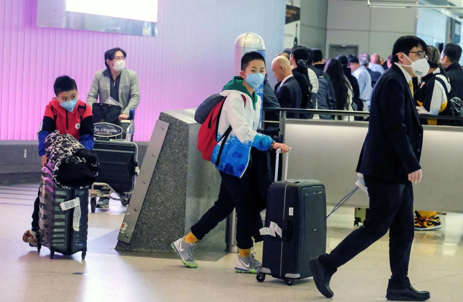 FILE PHOTO: Passengers arrive at LAX from Shanghai, China, after a positive case of the coronavirus was announced in the Orange County suburb of Los Angeles, California, U.S., January 26, 2020. REUTERS/Ringo Chiu

