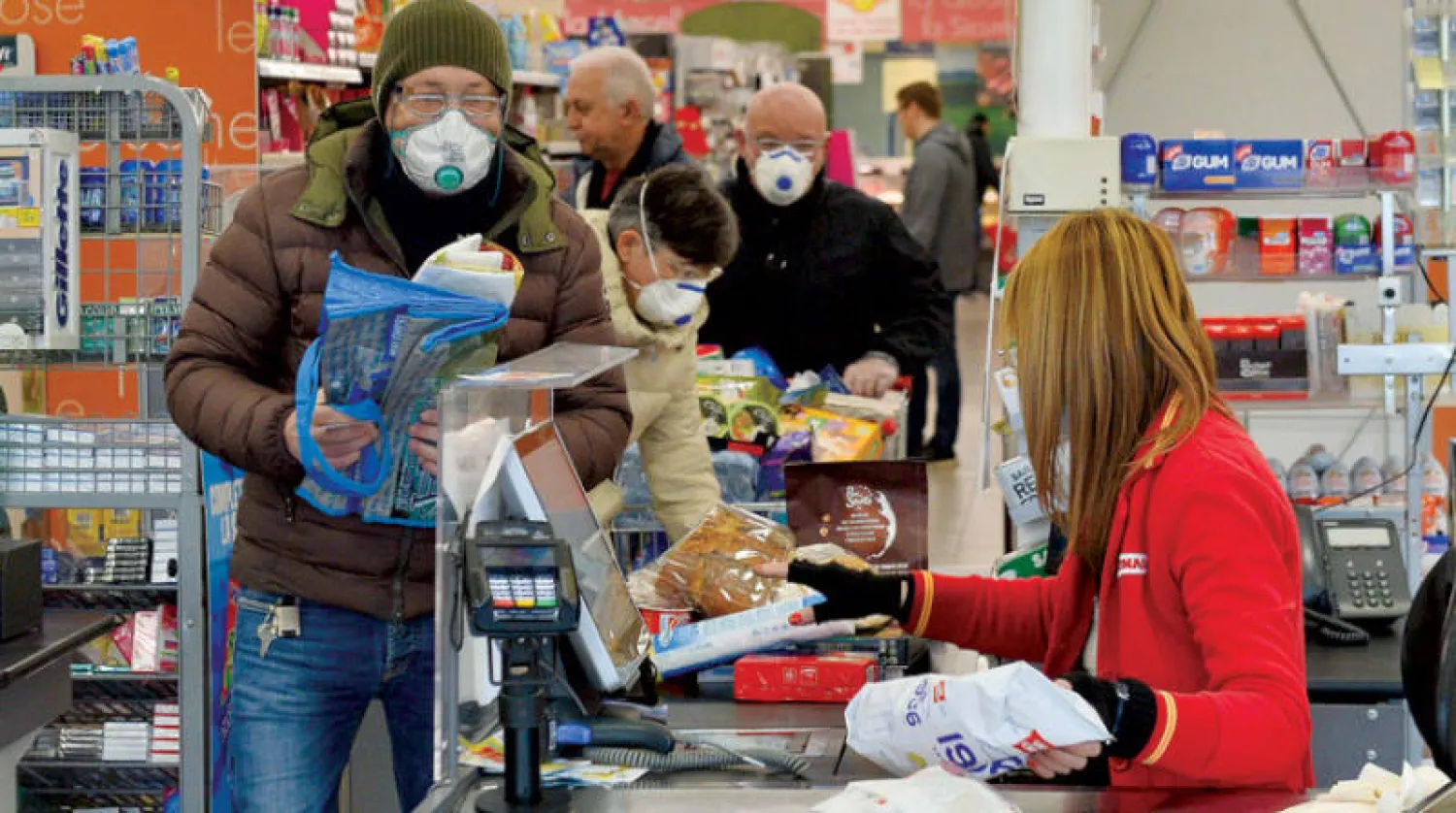 متسوقون يرتدون كمامات واقية من فيروس «كورونا» في «سوبر ماركت» بمدينة كاسالبوسترلينغو شمال إيطاليا أمس (إ.ب.أ)