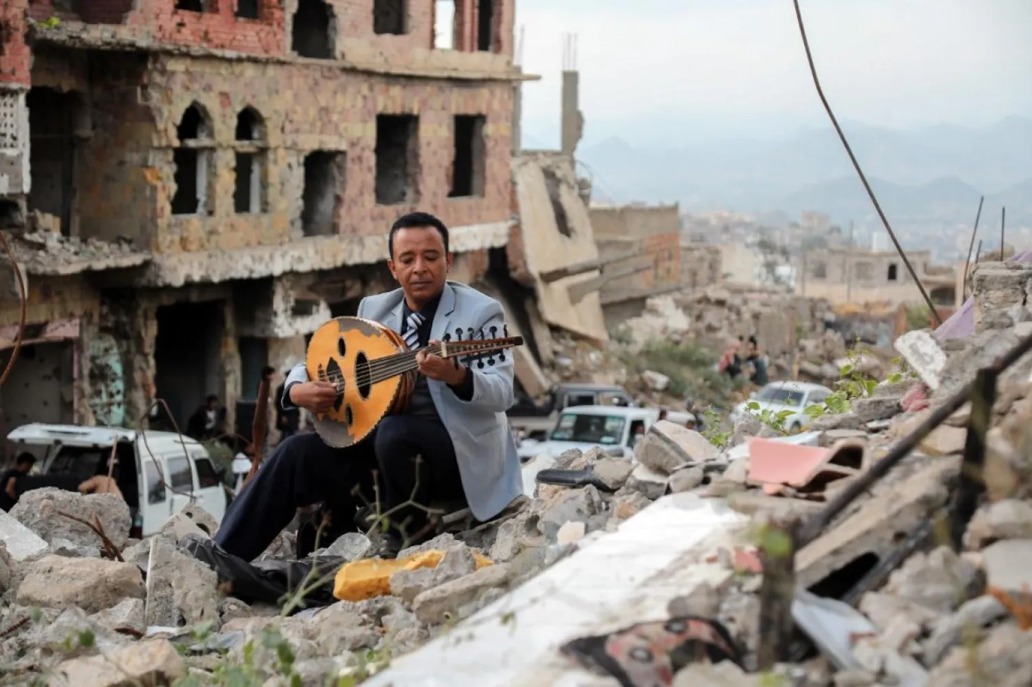 Harabeler arasında ud çalan Yemenli bir sanatçı (AFP)