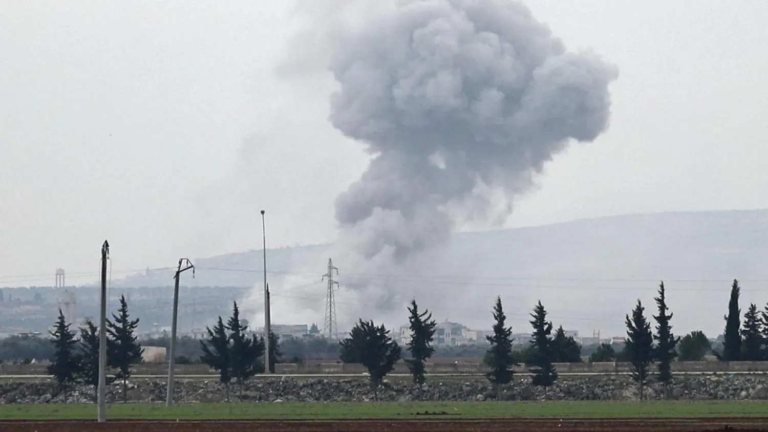A picture taken from the town of Sarmin in northwestern Syria on Friday shows smoke billowing over the village of Qaminas, near Idlib. (AFP)