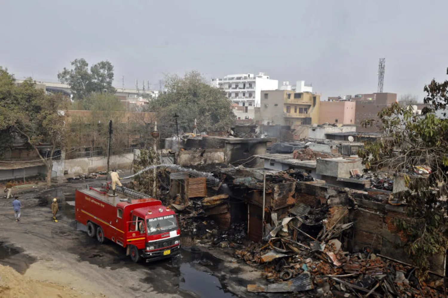 إخماد النار في متجر لإطارات السيارات أشعله مشاغبون في نيودلهي (رويترز)