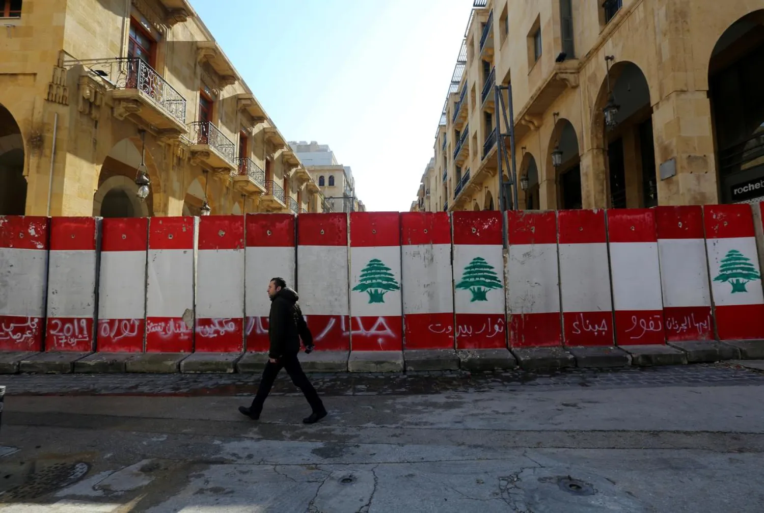 A man walks past concrete barriers erected by authorities to block a street leading to the parliament building in Beirut, Lebanon January 24, 2020. (Reuters)