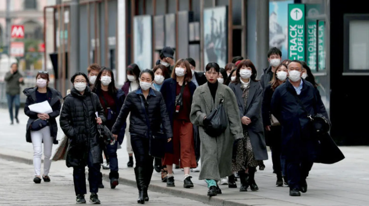 سائحون يتجوّلون في شوارع ميلانو بكمامات وقائية أمس (رويترز)