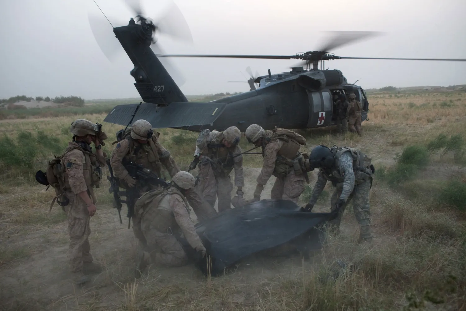 أعضاء مروحية إخلاء طبي يجمعون رفات عنصر من مشاة البحرية الأميركية الذي قتل في انفجار عبوة ناسفة في مقاطعة هلمند جنوب أفغانستان، في مايو (أيار) 2010