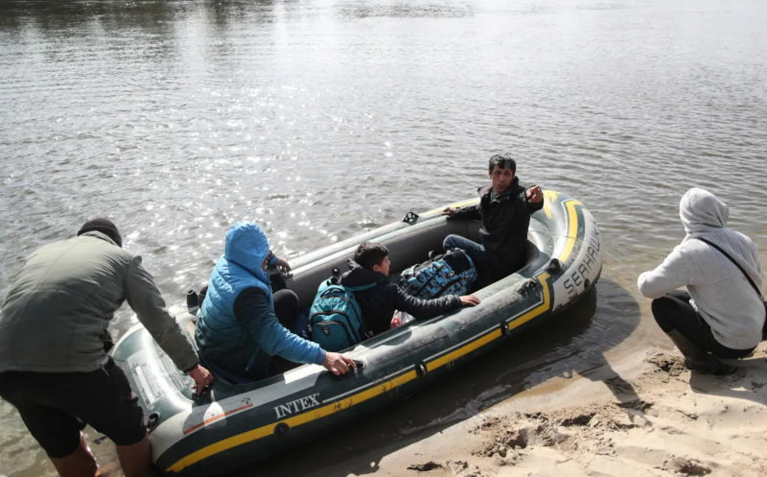 مهاجرون يركبون قاربا صغيرا لعبور نهر ميريك (إفروس) للوصول إلى الأراضي اليونانية  في أدرنة بتركيا (إ.ب.أ)