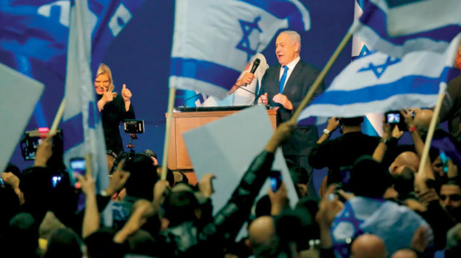 نتنياهو وزوجته سارة يحتفلان مع جمهور حزب الليكود بإعلان نتائج تقدم الحزب في الانتخابات (أ.ف.ب)