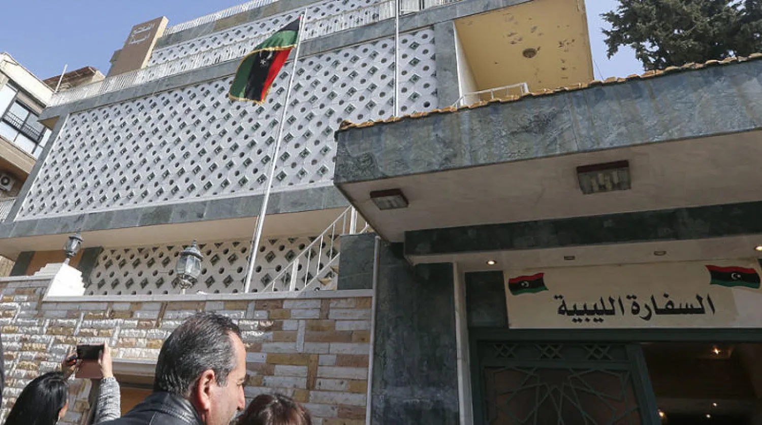 رفع العلم الليبي على السفارة في دمشق أمس (أ.ف.ب)
