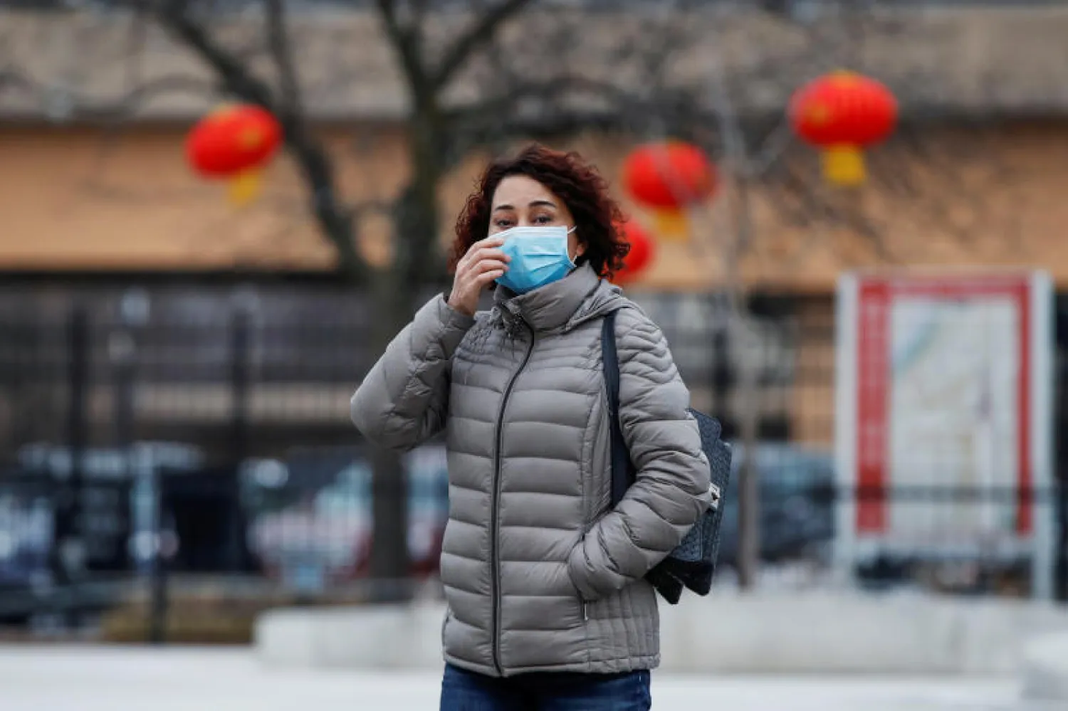 سيدة ترتدي كمامة واقية في أحد شوارع شيكاغو (رويترز)