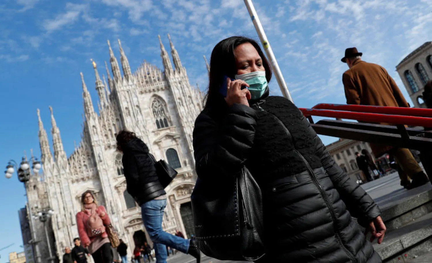 سيدة ترتدي قناعاً واقياً خوفاً من الإصابة بفيروس كورونا لدى دخولها إلى محطة لمترو الأنفاق في ميلانو (رويترز)