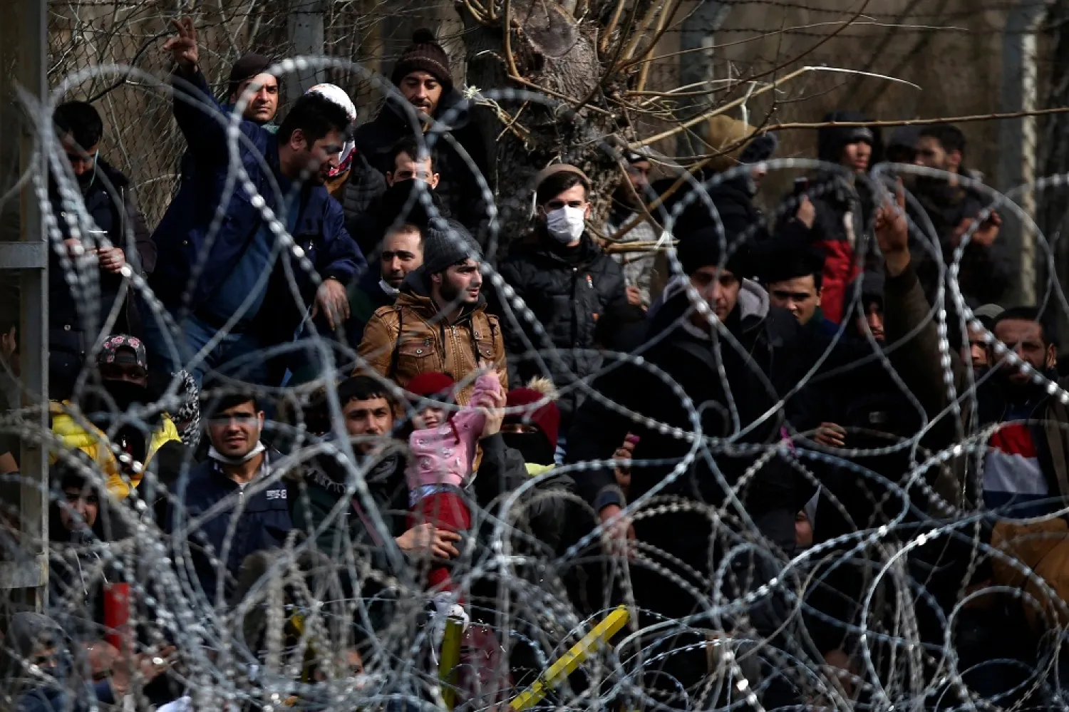 Migrants stand behind a fence near the Kastanies border gate at the Greek-Turkish border, March 1, 2020. (AP)