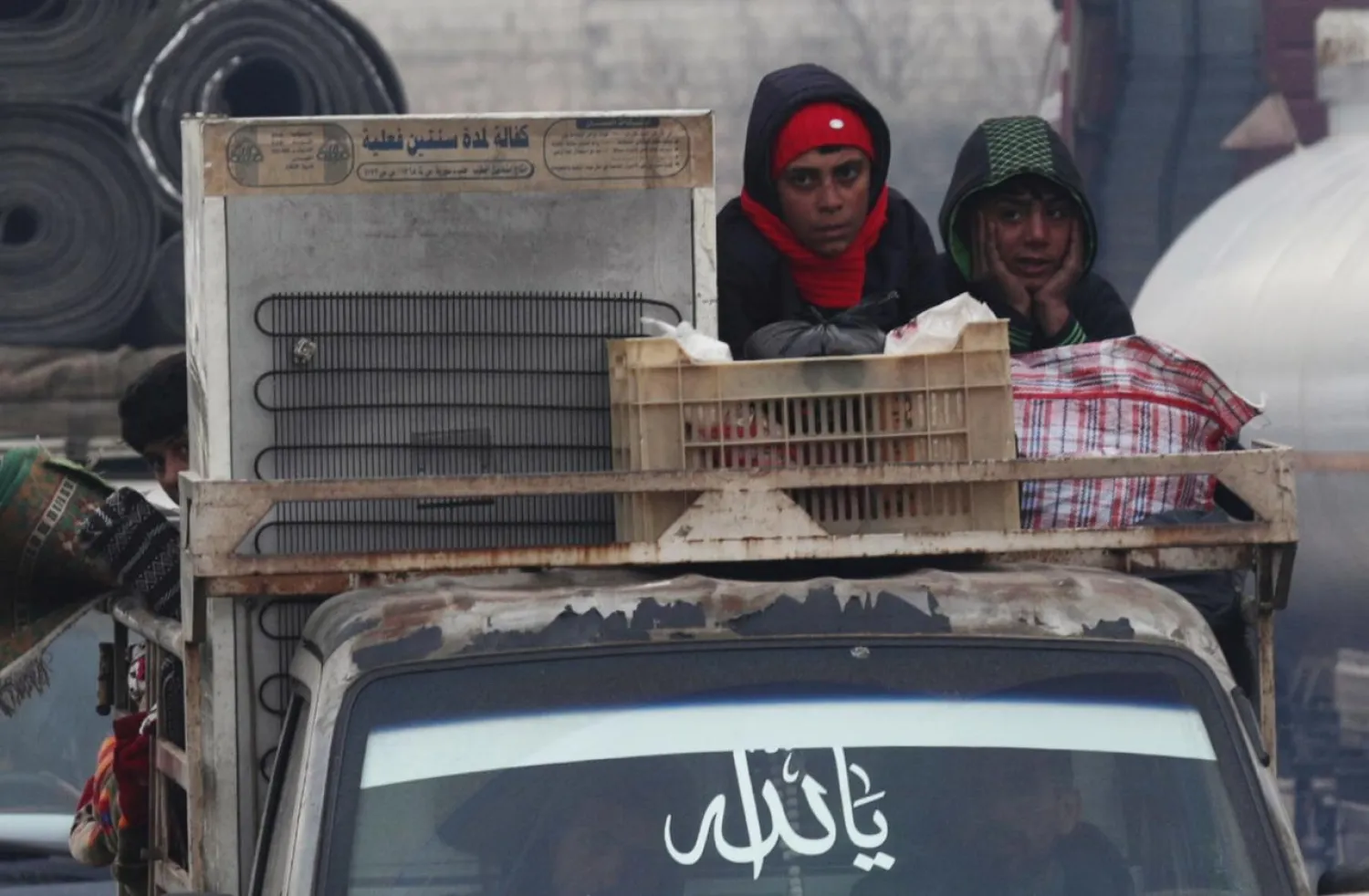 FILE PHOTO: Displaced Syrian boys ride on a truck with belongings in northern Idlib, Syria January 30, 2020. REUTERS/Khalil Ashawi