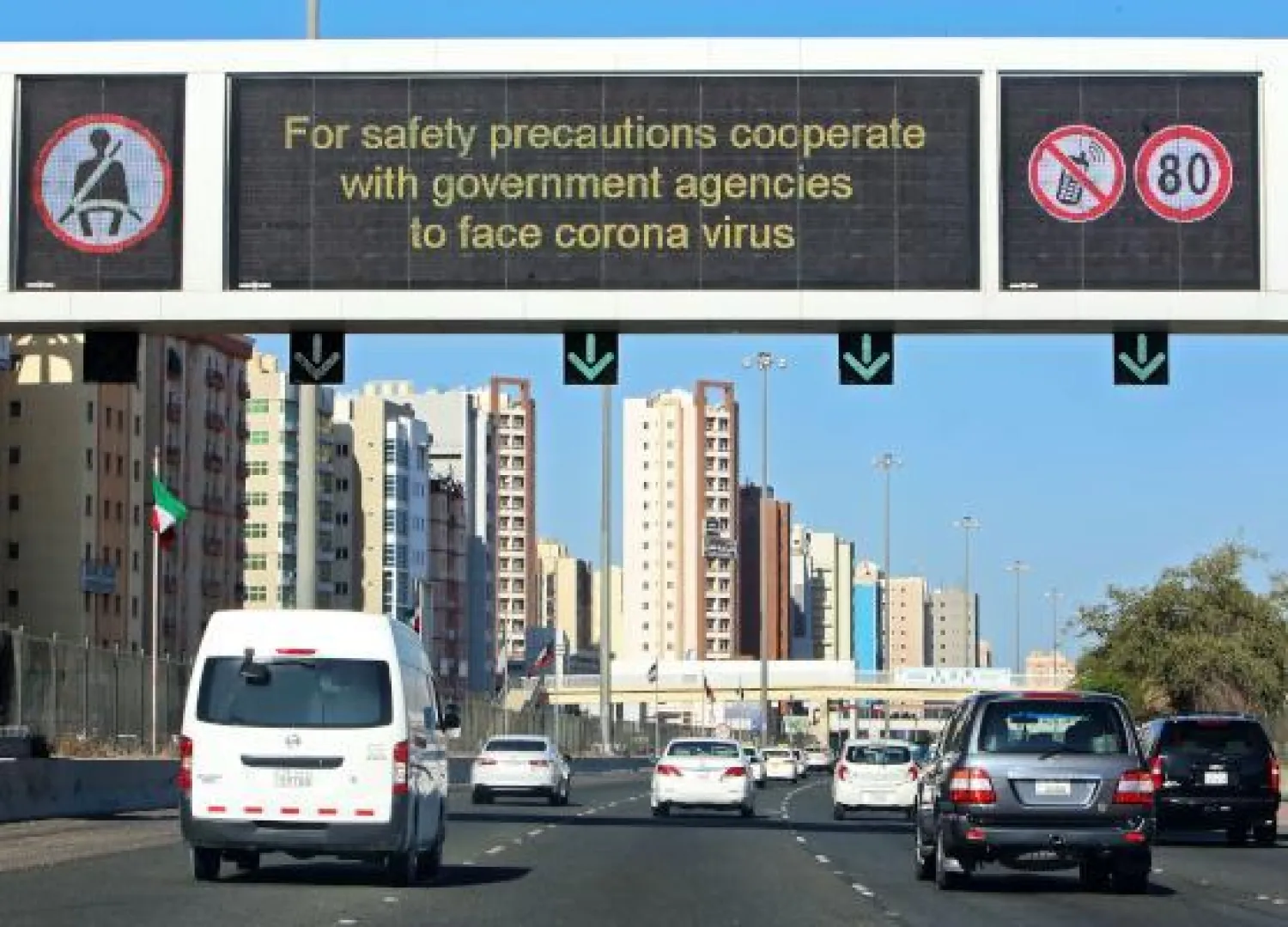 لوحة إرشادية في العاصمة الكويت تدعو للتعاون مع الجهات المختصة لمواجهة كورونا (ا.ف.ب)