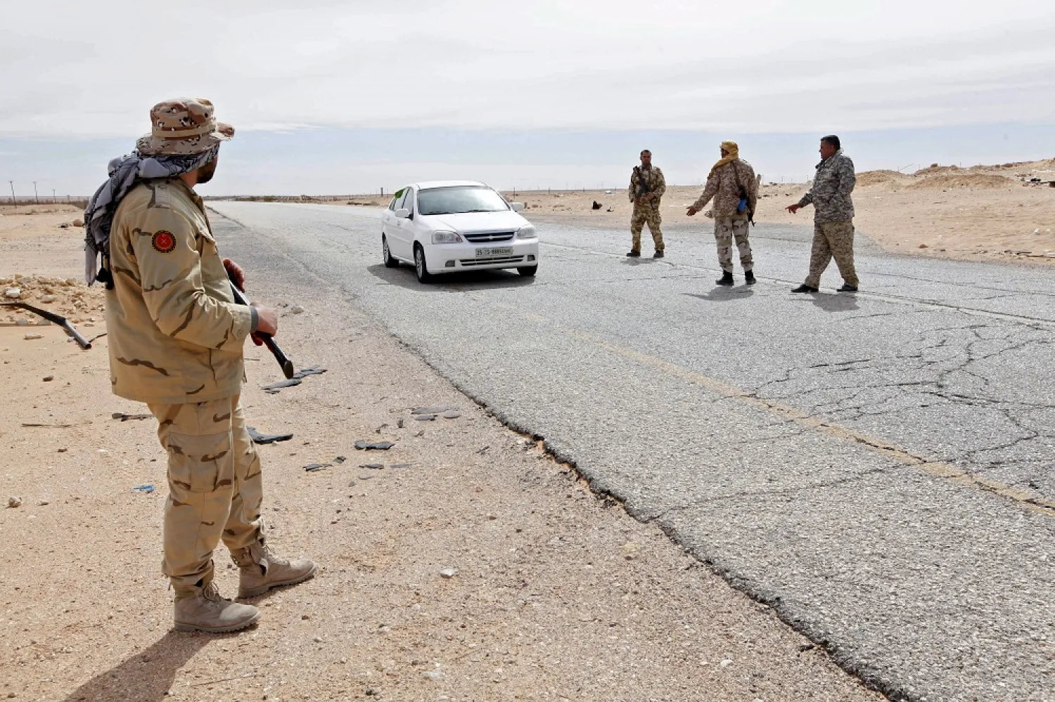 Libyan soldiers manning a military outpost, stop a car at a checkpoint in Wadi Bey, west of the city of Sirte. (Reuters)