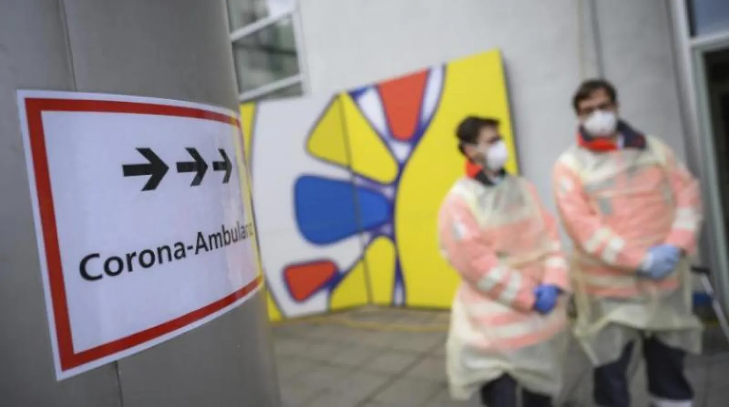 متطوعون بالصليب الأحمر الألماني أمام عيادة في شتوتغارت (أ.ب)