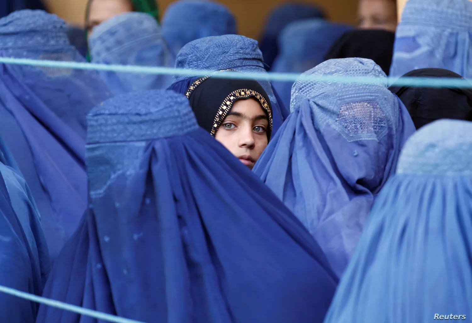 A girl looks on among Afghan women lining up to receive relief
assistance in Jalalabad, Afghanistan, June 11, 2017. Reuters.