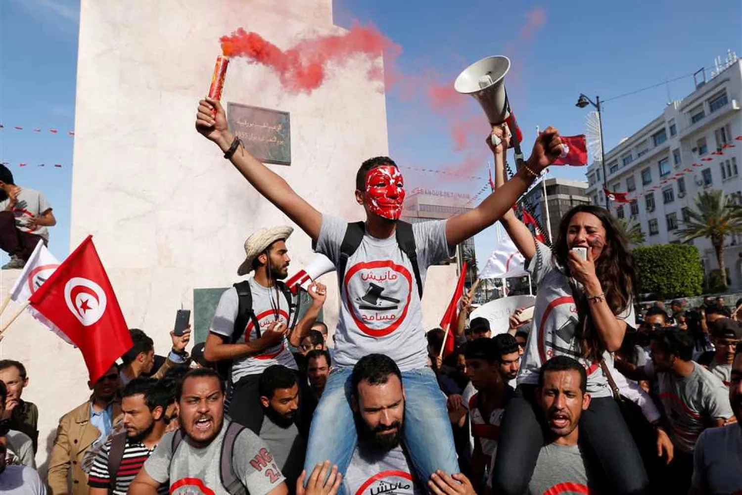 Demonstrators hold flares during a demonstration against a bill that would protect those accused of corruption from prosecution on Habib Bourguiba Avenue in Tunis, Tunisia. (Reuters file photo)