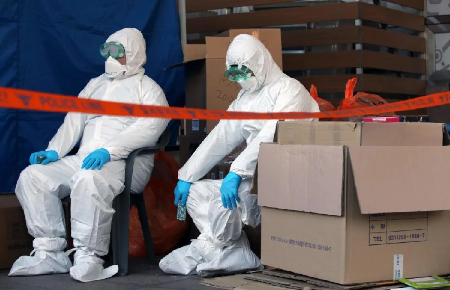 عنصران من فريق طبي يرتديان بدلات واقية في كوريا الجنوبية (أ.ف.ب)