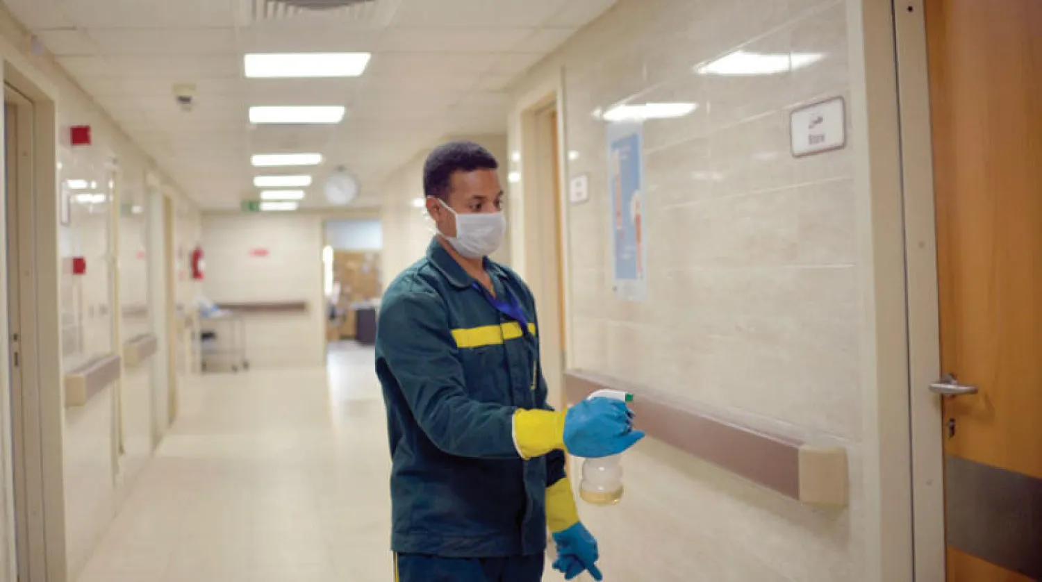 مصري يعقم أحد ممرات مستشفى الأقصر (إ.ب.أ)