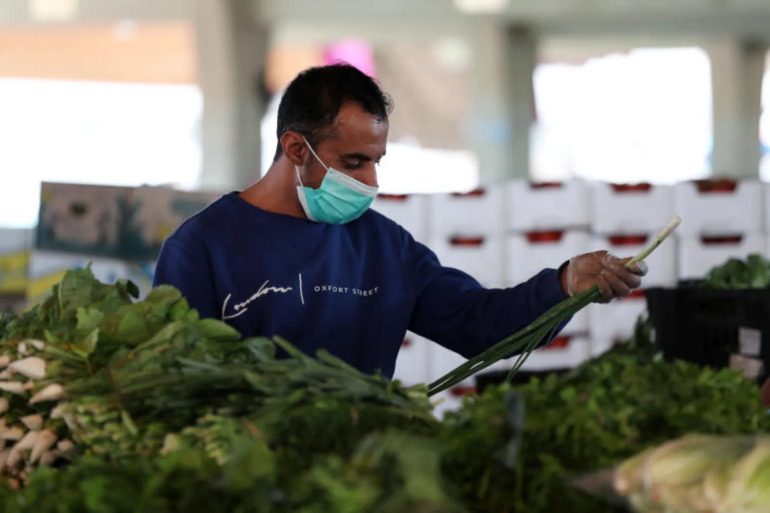 رجل يرتدي كمامة في أحد اسواق القطيف (رويترز)