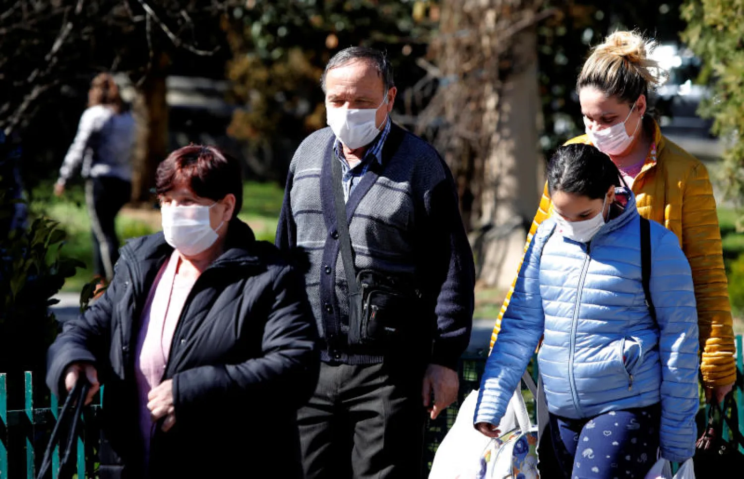 يضعون أقنعة واقية ضمن محاولات الحد من إنتشار فيروس كورونا في شمال مقدونيا (رويترز)