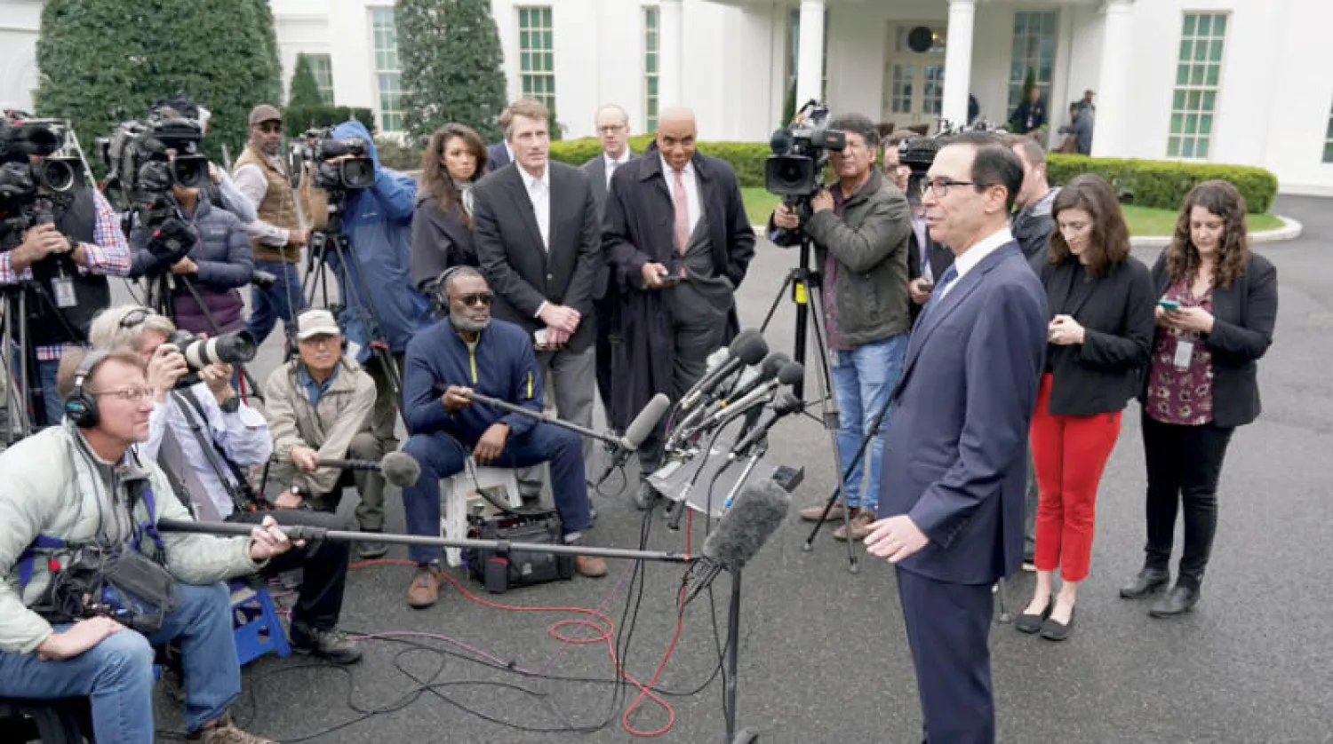 وزير الخزانة الأميركي متحدثاً للصحافيين عن تأثيرات كورونا على الاقتصاد بحديقة البيت الأبيض أمس (رويترز)