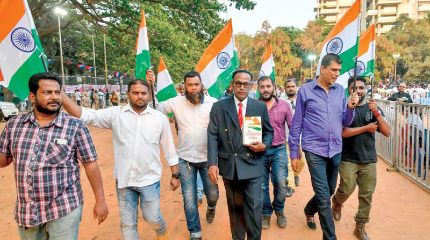 محتجون ضد قانون الجنسية المعدل يحمل أحدهم نسخة من الدستور الهندي ويرتدي هنداما ليظهر كأنه الدكتور بي آر امبدكار (وسط) الذي صاغ الدستور الهندي (أ.ف.ب)