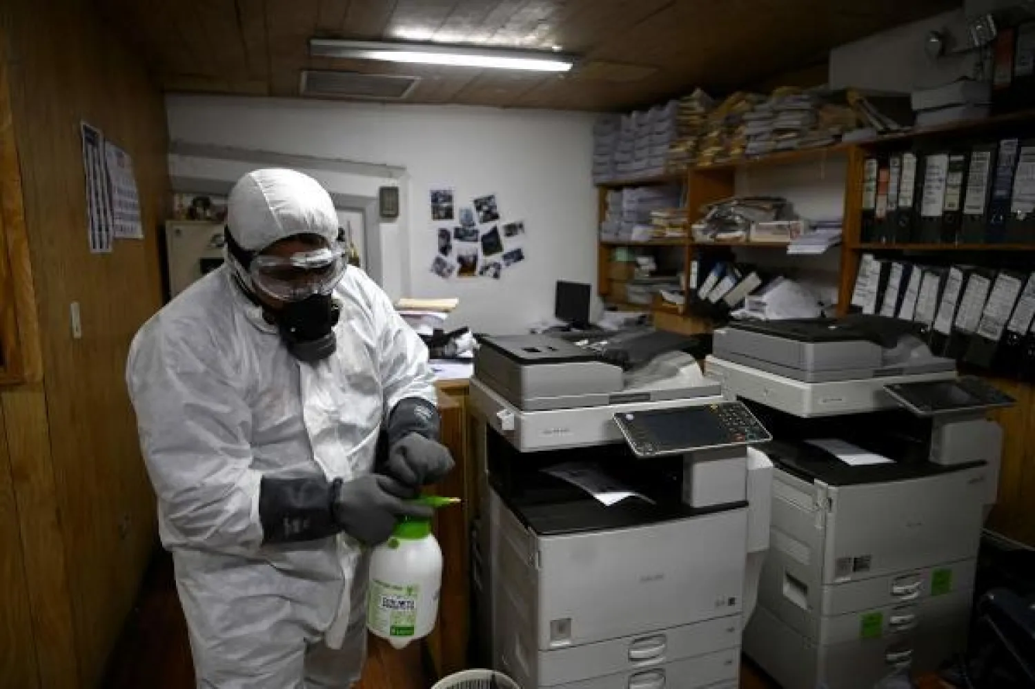 عامل يقوم بتطهير مكتب رئيس بلدية سان سلفادور كإجراء احترازي ضد وصول فيروس كورونا (ا.ف.ب)