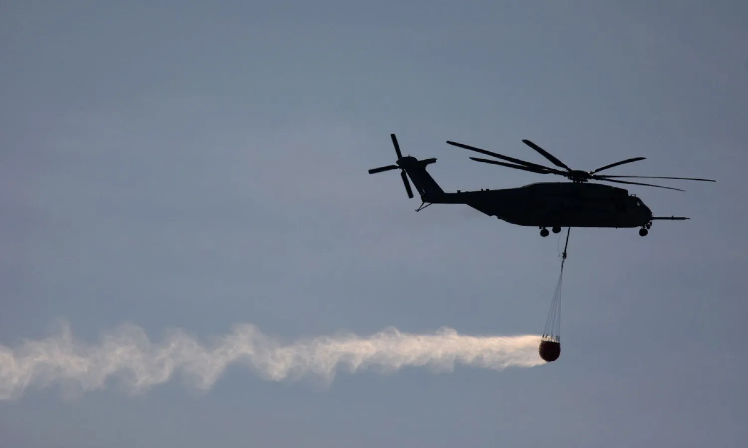 A CH-53 Super Stallion Marine helicopter carries a bucket of water scooped from the ocean to fight the Talega Fire on nearby Camp Pendleton on May 16, 2014 near San Clemente, California. (AFP)