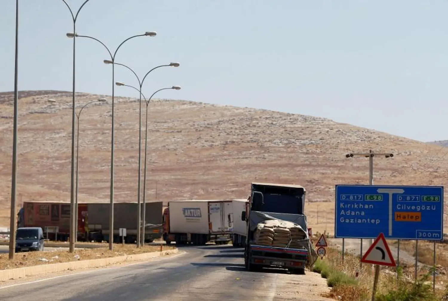 Commercial Turkish trucks wait to cross to Syria near the Cilvegozu border gate, located opposite the Syrian commercial crossing point Bab al-Hawa in Reyhanli, Hatay province, Turkey, September 16, 2016. REUTERS/Osman Orsal
