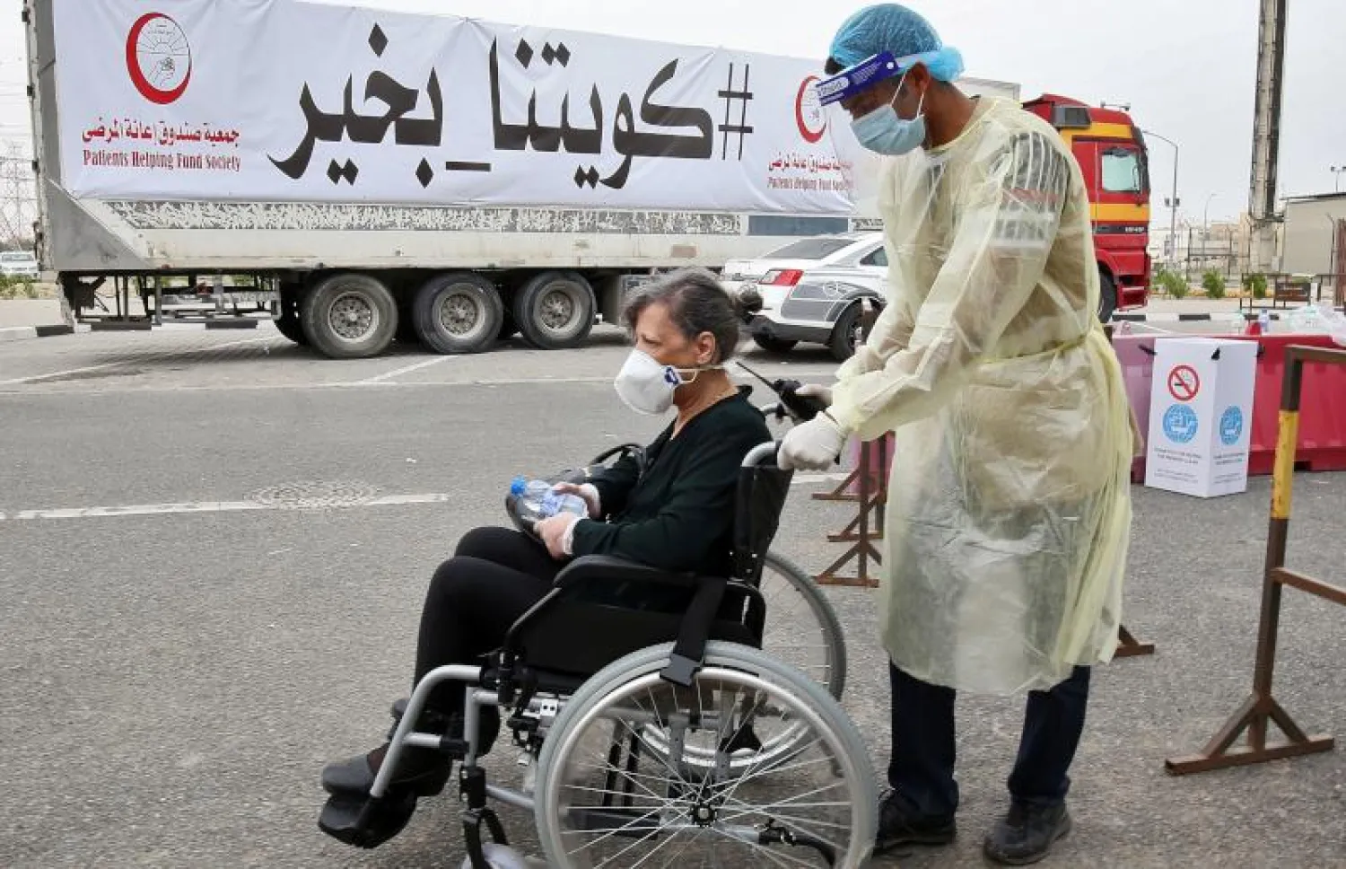 سيدة تصل إلى منطقة احتواء وزارة الصحة الكويتية لفحص فيروس كورونا للمغتربين (أ.ف.ب)