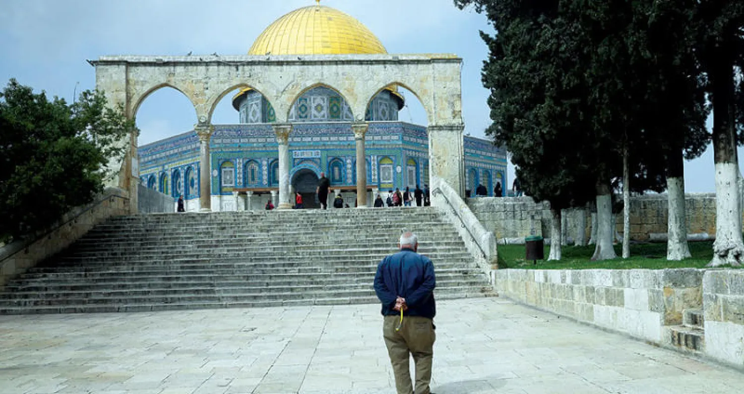 فلسطيني يمشي وحيداً أمام مسجد قبّة الصخرة أمس (أ.ب)