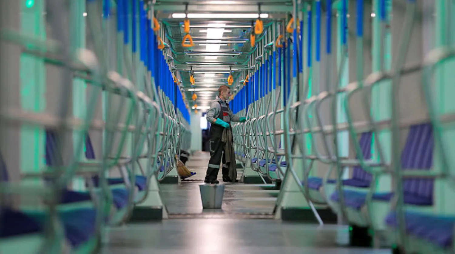 موظّف يعقّم قطار أنفاق في موسكو أمس (رويترز)