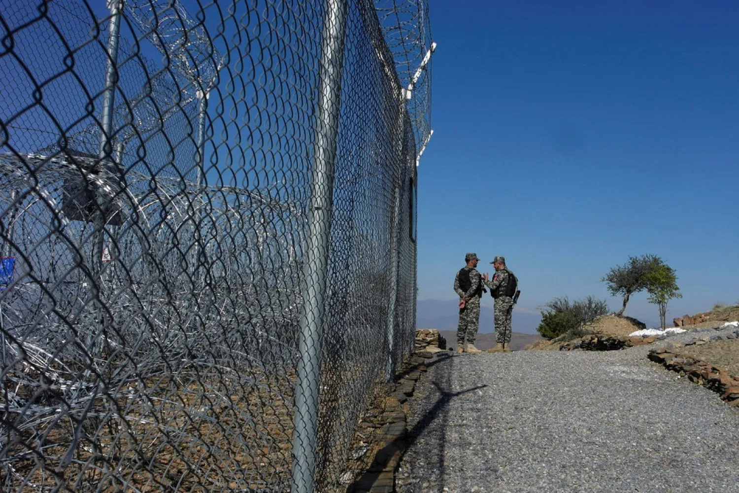 Pakistani soldiers near a security fence at the border post in Torkham, Pakistan, in December. Credit Salahuddin/Reuters
