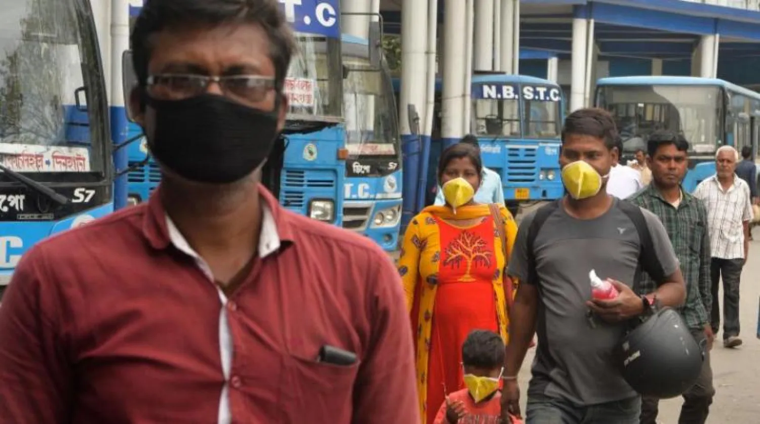 Hindistan vatandaşları koronavirüsün yayılmasını engellemek için maske takıyorlar. (AFP)