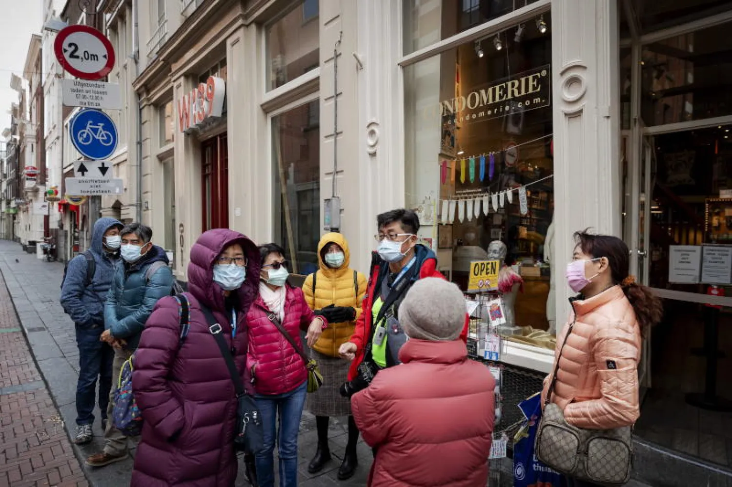 مجموعة من الأشخاص يرتدون الكمامات في أمستردام بهولندا (إ.ب.أ)