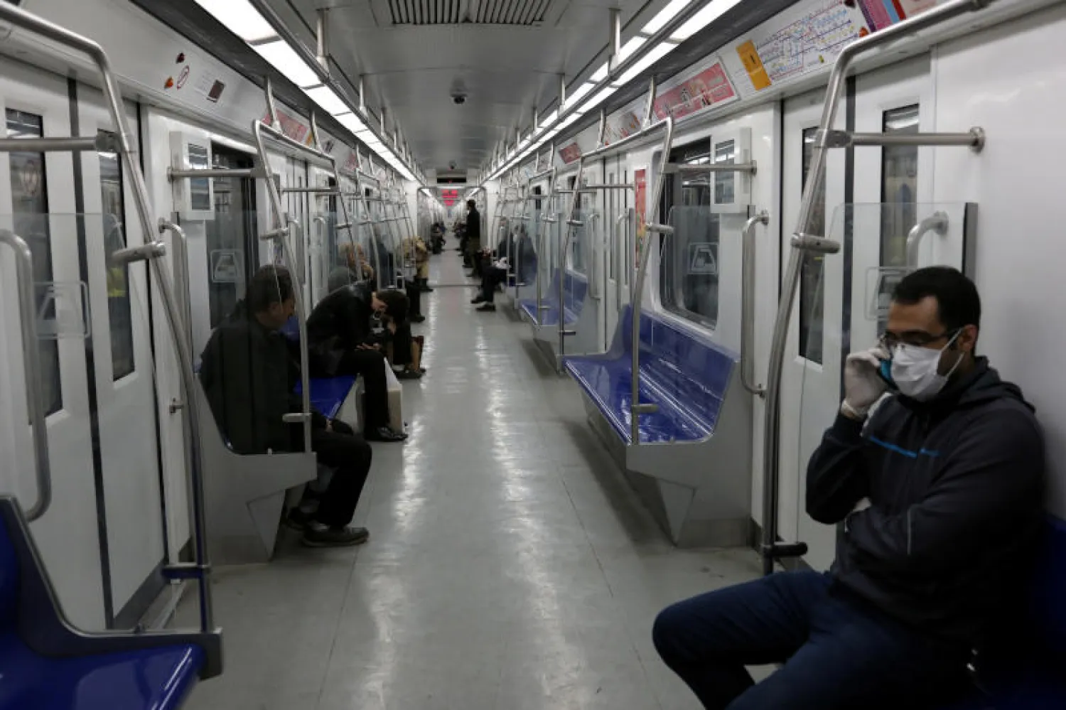 ركاب يرتدون الأقنعة الواقية في إحدى عربات المترو بطهران (رويترز)