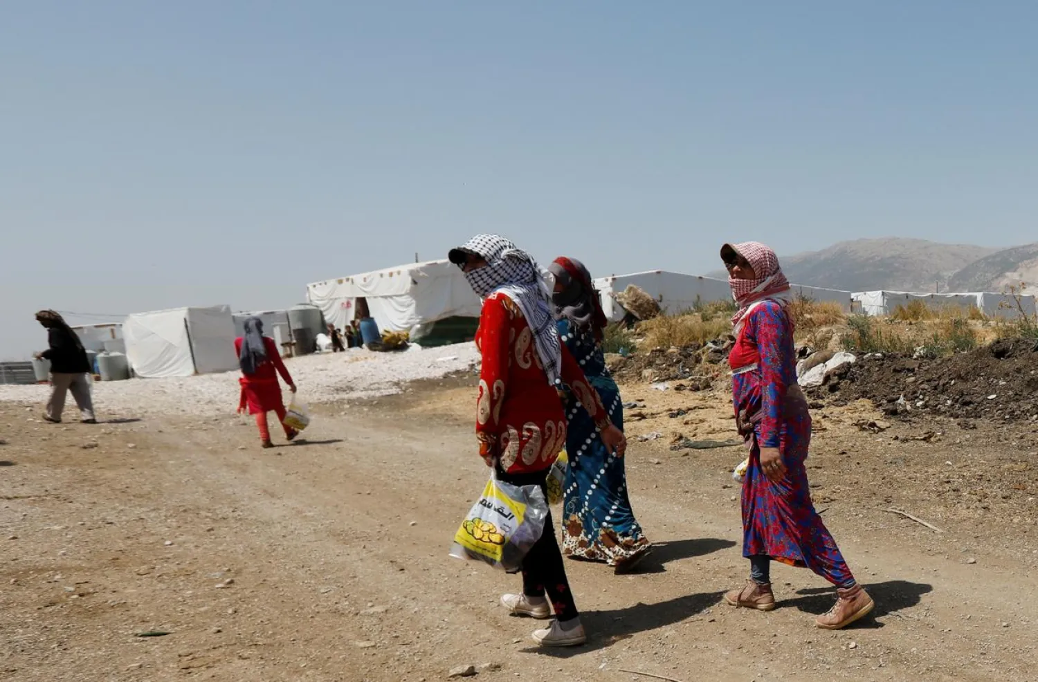 Syrian refugee women walk together at a camp for Syrian refugees near the town of Qab Elias, in Lebanon's Bekaa Valley, August 8, 2017. REUTERS/Jamal Saidi
