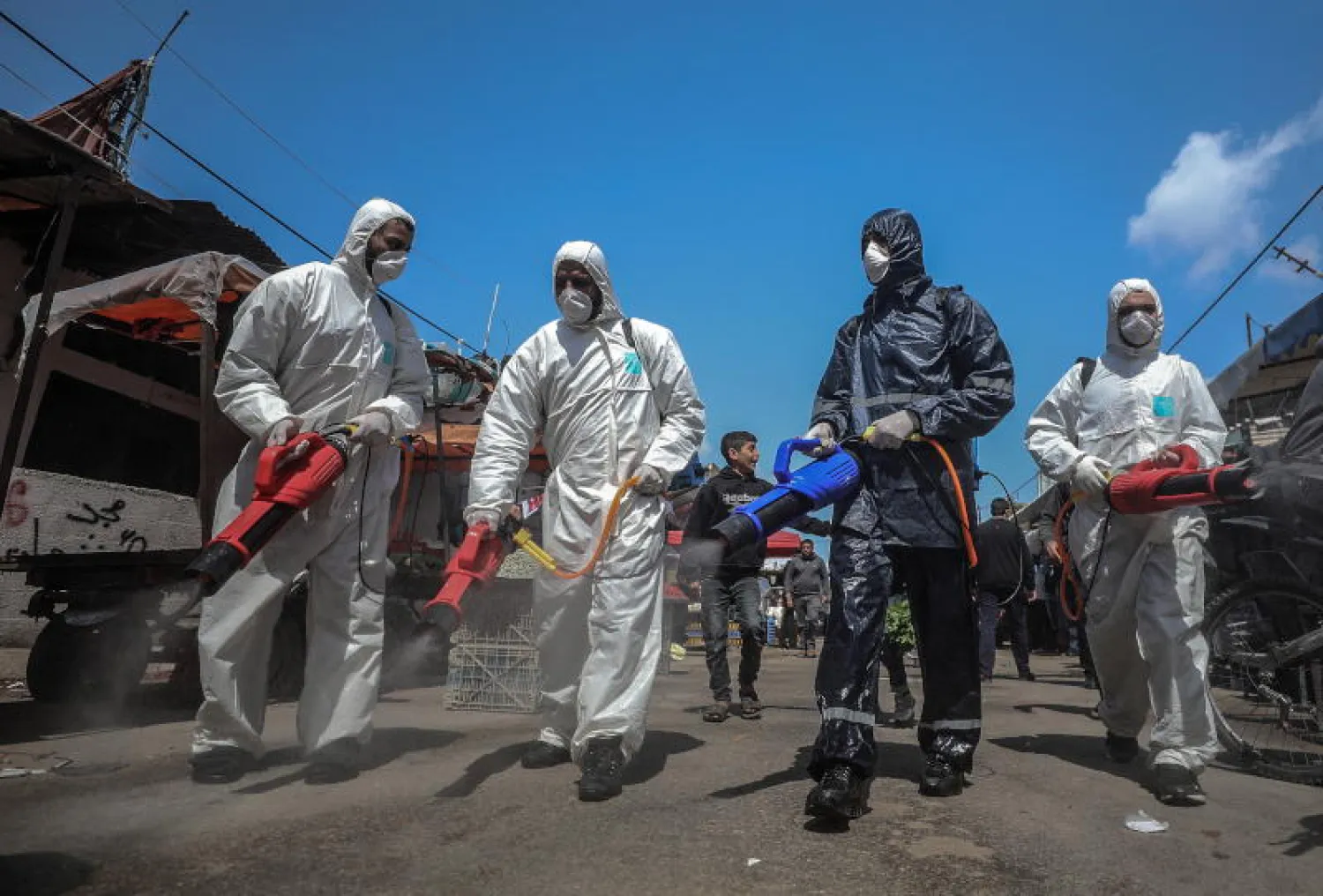 فلسطينيون يعقمون الطرق قي قطاع غزة (إ.ب.أ)