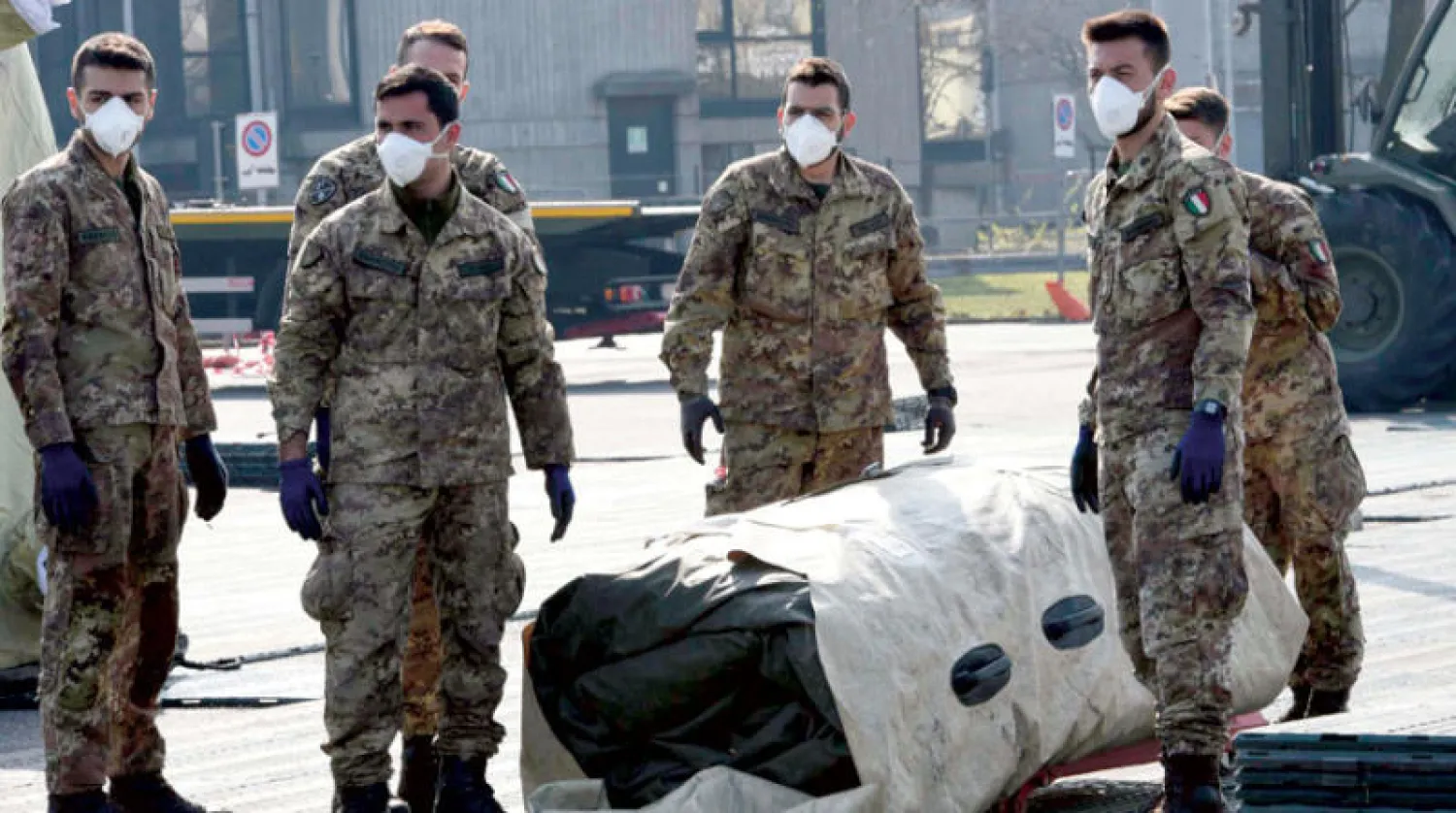 جنود إيطاليون يستعدون لنصب خيام طبية خاصّة بمرضى «كورونا» في كريما شمال البلاد (إ.ب.أ)