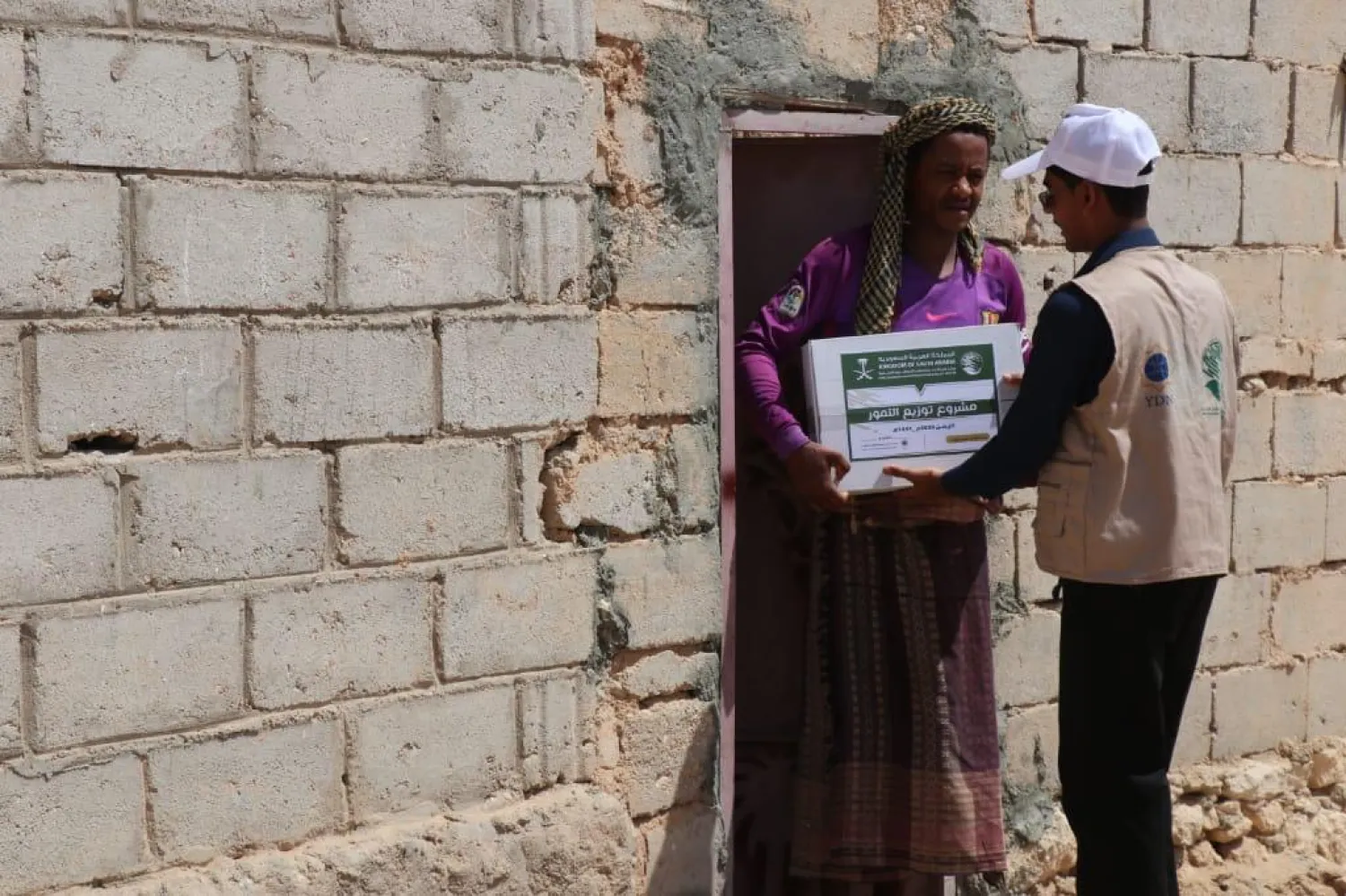 King Salman Center for Relief and Humanitarian Work (KSRelief) worker distributing aid in Yemen (KSRelief)