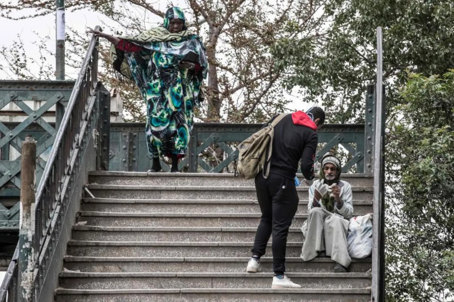 متطوع يعطي رجلا فقيرا قناعا واقيا في أحد شوارع القاهرة لمواجهة «كورونا» (أ.ف.ب)