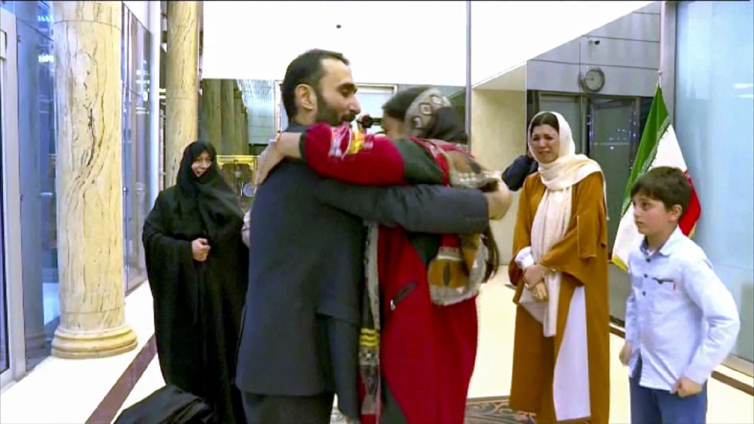 An image grab from footage obtained from Iran Press news agency on March 21, 2020, shows Jalal Rohollahnejad (C-L) greeting a relative upon his arrival in Tehran. (AP)